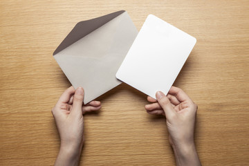 Obraz premium woman hand hold a letter and envelope on the wood table.