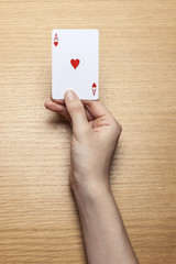 woman hand hold a card on the wood table.