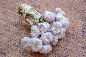 Garlic bulbs with garlic cloves on the vintage wicker or basketwork.