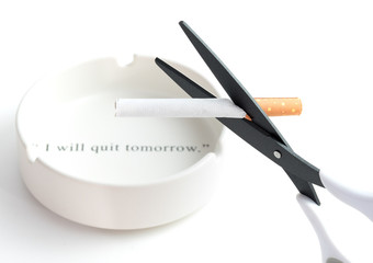 black blade scissors cutting cigarette with blurred white ashtray with quote 