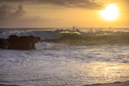 Sunset wave crashing against rock on a beach in Pacific oecan. Beautiful seascape scenery