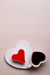 Heart shaped coffee cup and cake on wood surface