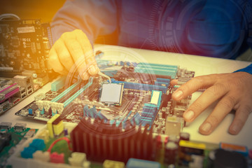 Hands of a technician assembling computer hardware parts, as a new cpu is being mounted unto the motherboard.