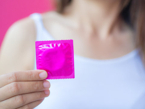 Hand holding condom, selective focus, save sex concept.