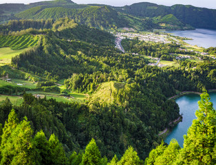 Aerial view of green valley between mountains with a lake