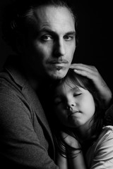 Father holding in embrace sleeping daughter 