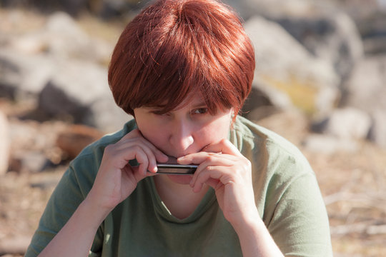 Woman Playing A Harmonica