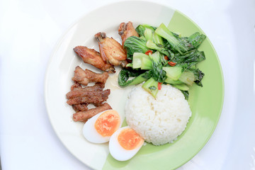 stir fried vegetables, Hard-boiled egg, Fried pork and Fried chicken wings with thai jasmine rice on dish. Thai food.