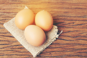 Eggs in basket with old beautiful wooden background.