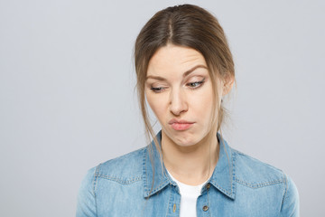 Closeup portrait of skeptical young woman with makeup looking suspicious showing negative emotions...