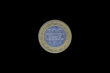 Bahrain 100 fils coin with the image of the coat of arms of the Kingdom isolated on black background.