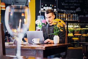 A man using laptop in a cafe.