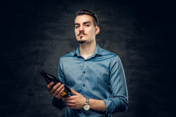 A man holds craft bottled beer.