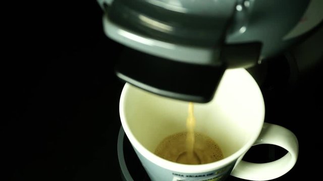 Closeup of coffee with milk preparation from capsule - Dolce Gusto Mini Me.