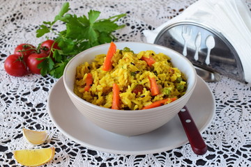 Easy to cook dish with rice, carrots, onions raisans and olive oil in a bowl on a white background. Healthy eating concept