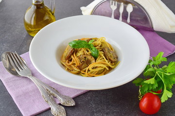Pasta with mushrooms and pesto sauce in a white plate on abstract bckground. Italian lifestyle. Healthy eating concept