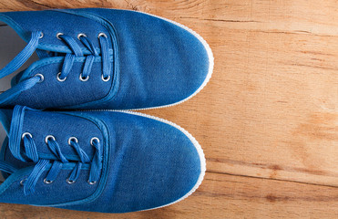 Blue sneakers close up on wood desk