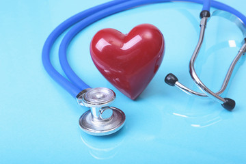Medical stethoscope and red heart isolated on mirror background.