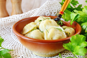 Traditional russian pelmeni with minced meat and onions filling in a brown ceramic bowl