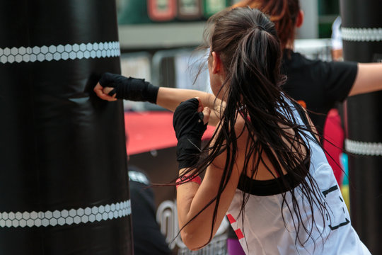 Young Girl with Shorts and White Tank Top: Fitness Boxing Workout with Punching Bag