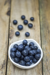 Freshly picked blueberries in wooden bowl. Juicy and fresh blueberries on rustic table