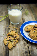 Glass of milk and cookies on wooden table. Top view