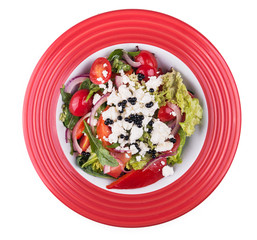 Greek salad with vegetables and feta in red dish
