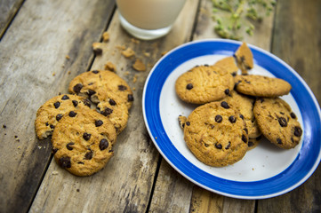Glass of milk and cookies on wooden table. Top view