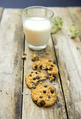 Glass of milk and cookies on wooden table. Top view