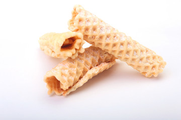 Homemade wafer rolls with powdered sugar isolated on white background