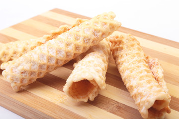 Homemade wafer rolls with powdered sugar isolated on white background