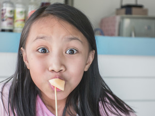 beautiful asian child are eating fruit in the restaurant.