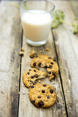 Glass of milk and cookies on wooden table. Top view
