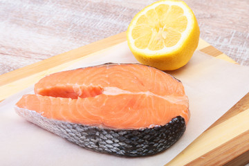 fresh raw salmon with spices and lemon on wooden cutting board. ready for cookin