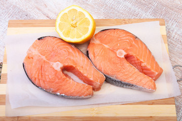 fresh raw salmon with spices and lemon on wooden cutting board. ready for cookin