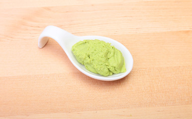 plate with Japanese wasabi sauce on wood background.