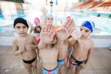 Obraz na płótnie Canvas happy children kids group at swimming pool class learning to swim