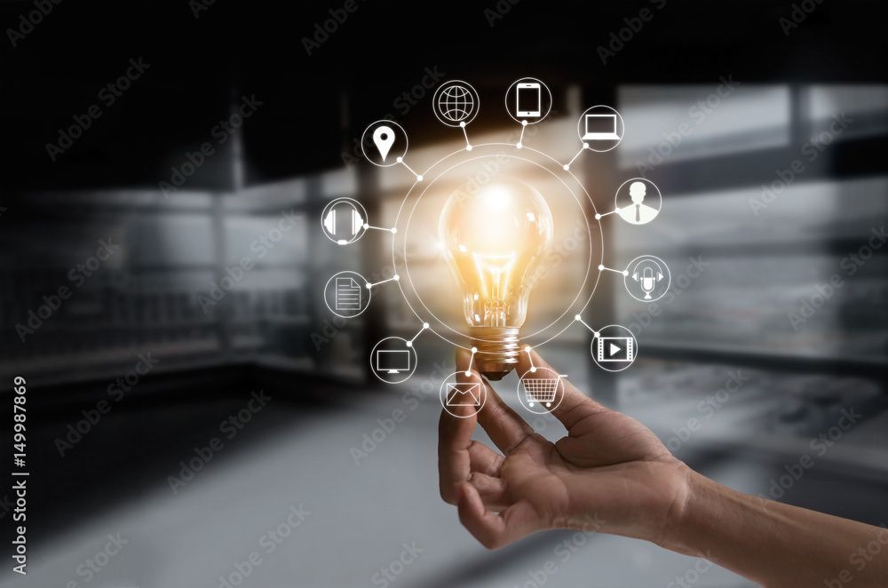 Poster Hand holding light bulb with icons multimedia and customer network connection on dark room background