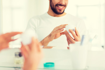 close up of happy young man with cream at bathroom