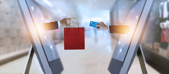 e-commerce, hand holding shopping bag and credit card from screen and global network, shopping and payments online concept