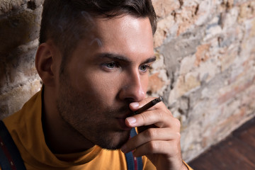 Young sad guy with cigarette in his mouth