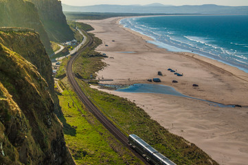 Obraz premium Tor kolejowy między Londonderry i Coleraine w pobliżu Oceanu Atlantyckiego, jedna z najpiękniejszych podróży koleją na świecie.