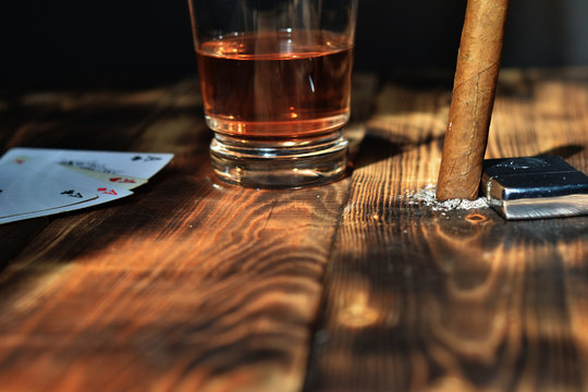 Glass With Alcohol Cigarettes And Play Cards On A Wooden Table