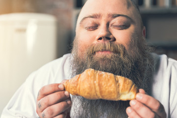 Man smelling pastry