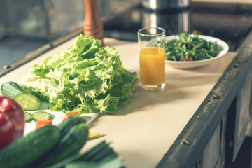 Fresh vegetables and beverage on counter in kitchen
