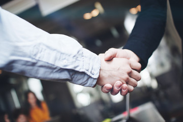 Two business partners shake hands after a successful deal. Close up view of business partnership...
