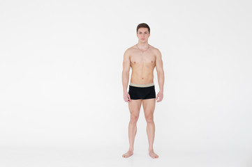 Fototapeta na wymiar studio portrait young sexy men bodybuilder athlete, with a bare torso, Standing in full length on a white background in underwear underwear, Belt is photographed, gold chain with a cross on the neck