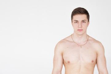 Fototapeta premium studio portrait young sexy men bodybuilder athlete, with a bare torso, Standing in full length on a white background in underwear underwear, Belt is photographed, gold chain with a cross on the neck
