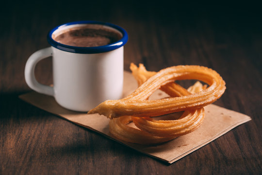 Close up of chocolate with churros on parchment paper