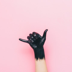 surf Shaka gesture by black painted hand on pink background. minimal style of summer - obrazy, fototapety, plakaty